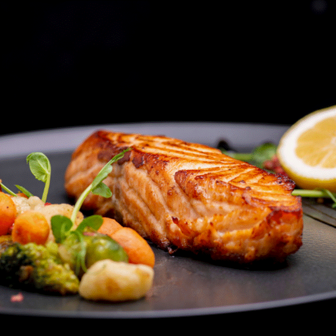 A plate of food with a lemon and vegetables

AI-generated content may be incorrect.