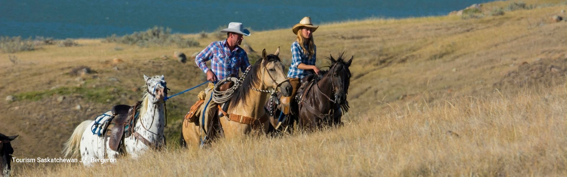 Two horse riders exploring scenic Saskatchewan landscape