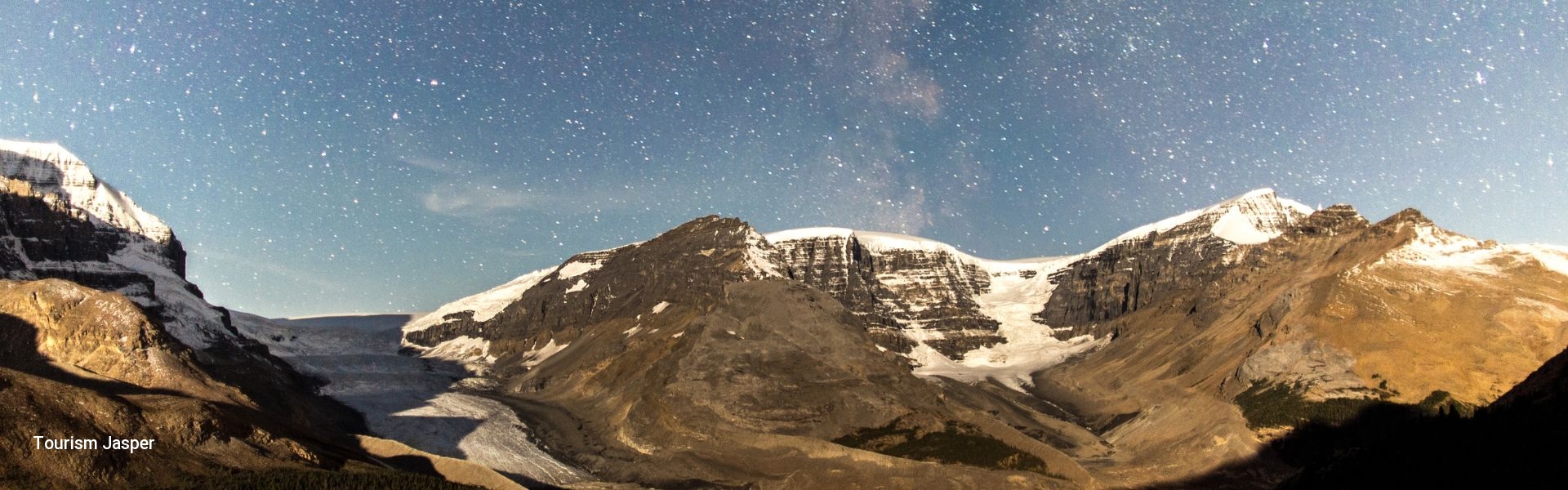 A nighttime photo of the Jasper mountains, with many bright stars.